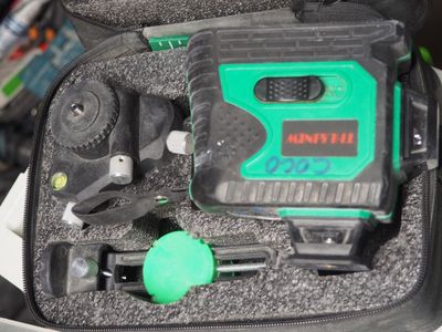 un objet vert et noir dans un étui posé sur une table