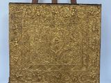 un vieux chevalet en bois surmonté d'un tableau doré