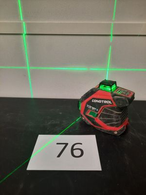un gros plan d'un laser vert posé sur une table, avec une pancarte
