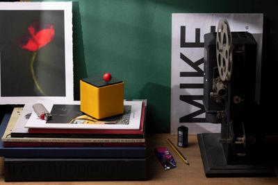 a yellow box sitting on top of a stack of books next to a camera
