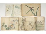 a group of four books with drawings of flowers and birds