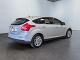 the back end of a silver ford focus parked in a room