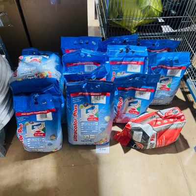 many bags of water sitting on the floor next to a shopping cart