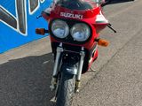 une moto rouge garée devant un immeuble