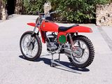 a red dirt bike parked on the side of the road