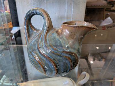 un vase bleu et marron posé sur une table en verre