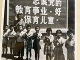 an old photo of a group of children standing in front of a sign