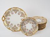 un service de six assiettes ornées d'une bordure dorée et de motifs floraux