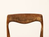 an image of a wooden chair against a white wall