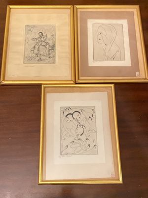 trois dessins encadrés représentant une femme et un homme, posés sur une table