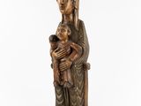 a wooden statue of a woman holding a child