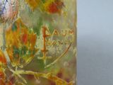 a close up of a vase with leaves on it