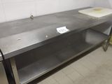 a stainless steel table with a cutting board on top of it