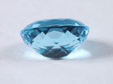a close up of a blue diamond on a white surface