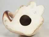 a white vase with a brown handle on a white surface