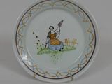 une petite assiette sur laquelle est représentée une femme assise par terre