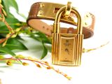 a close up of a wrist watch with a flower in the background