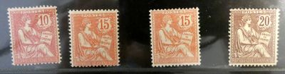 Quatre timbres de couleurs différentes sont exposés dans une vitrine.