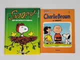 Deux livres mettant en scène Charlie Brown et Snoop sont posés sur une table