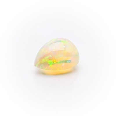 a white oplite stone with yellow and green speckles on it