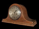 a wooden clock that is sitting on a black background