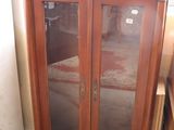 a wooden cabinet with glass doors in a room