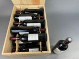 bottles of wine are in a wooden box on a gray surface
