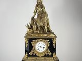 une statue représentant une femme et un chien posée sur une table