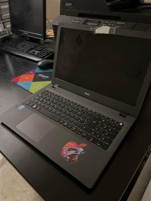 un ordinateur portable posé sur un bureau, à côté d'un écran d'ordinateur
