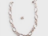 a close up of a necklace and earring on a white surface
