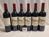 six bouteilles de vin rouge sont alignées sur une table