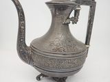 an antique silver tea pot with a handle on a white background