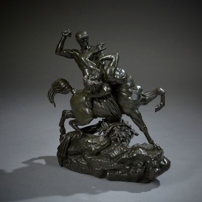 bronze statue of a man on a horse on a rock