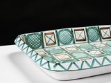 a green and white tray with geometric designs on it