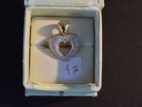 a diamond heart pendant in a box with a price tag