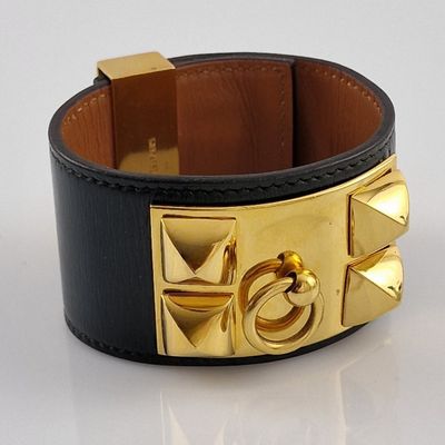 leather cuff bracelet with gold plated metal accents on a white surface