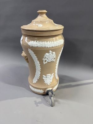 un vase marron et blanc avec un couvercle, posé sur une table