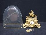 a gold clock with a glass dome on top of it