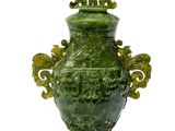 un vase vert posé sur une surface blanche