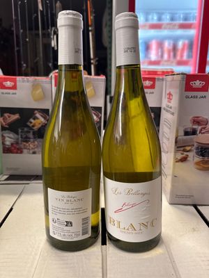 deux bouteilles de vin posées sur une table l'une à côté de l'autre