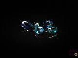 a close up of a group of blue and green gems on a black surface