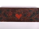 a close up of a wooden plaque with a red heart on it