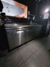 un homme debout dans une cuisine, avec un lave-vaisselle devant lui