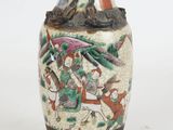 a vase with a painting on it sitting on a table