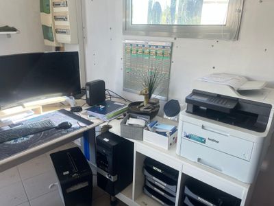 a desk with a computer, printer, and printer on it