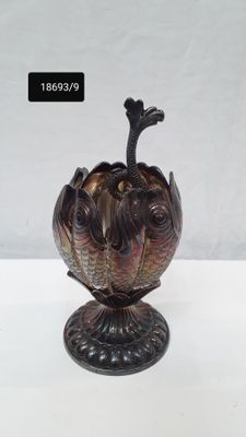 a vase with a bird on top of it on a table