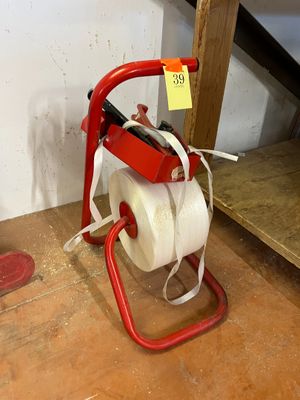 un distributeur de papier toilette posé par terre à côté d'une paire de chaussures
