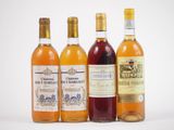 quatre bouteilles de vin sont alignées sur une surface blanche