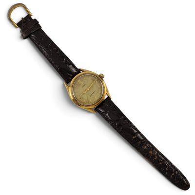 a close up of a watch on a black strap on a white surface