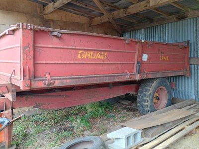 un camion-benne rouge garé dans un hangar